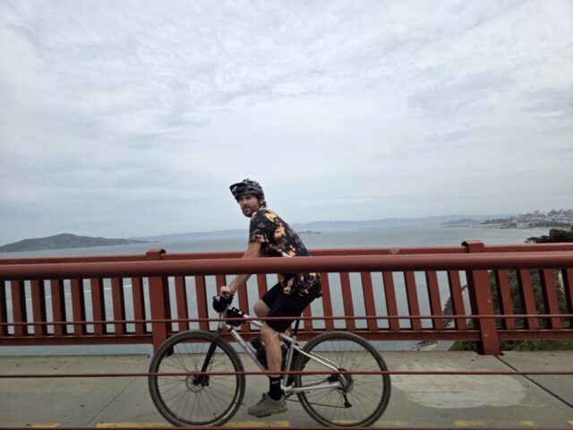 Biker on the side of The iconic Golden Gate Bridge stretching across the San Francisco Bay.